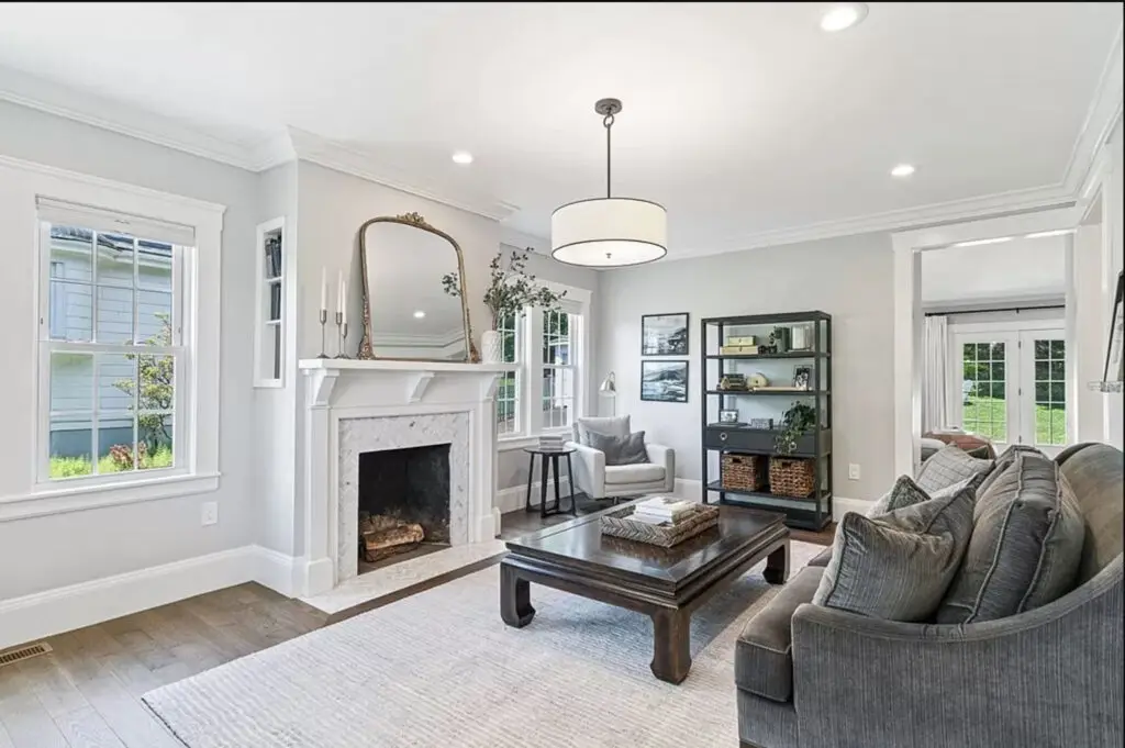 Living room with a fireplace, wood mantel and herringbone tiles on the face of the fireplace