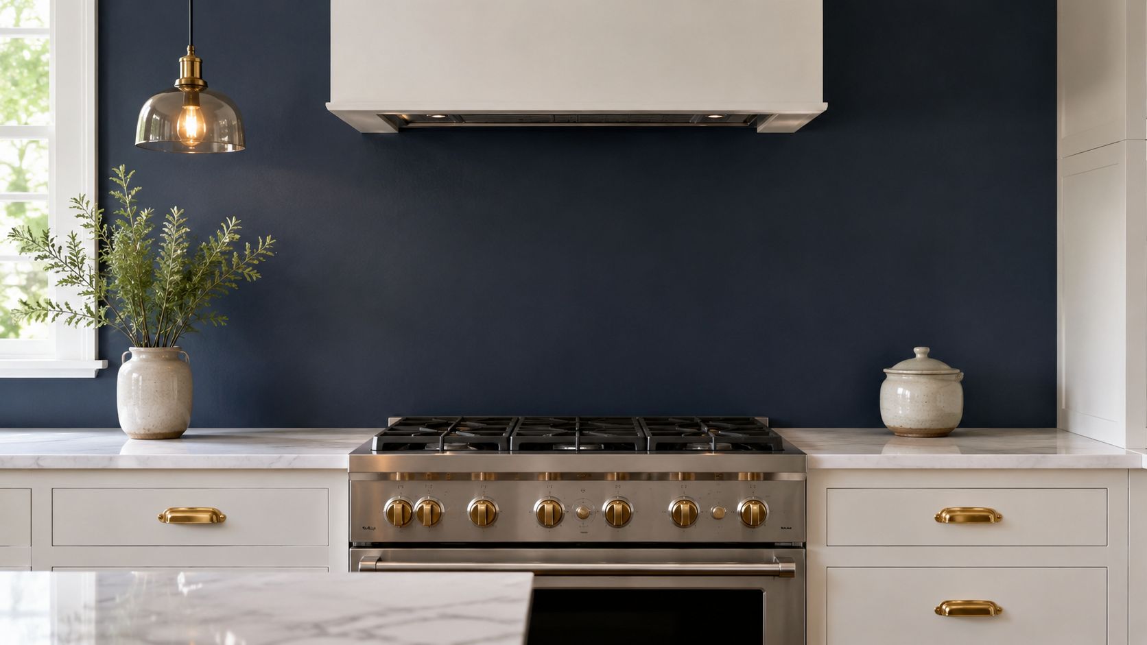 A modern kitchen with a dark navy blue wall acting as a stylish backsplash behind a stove.
