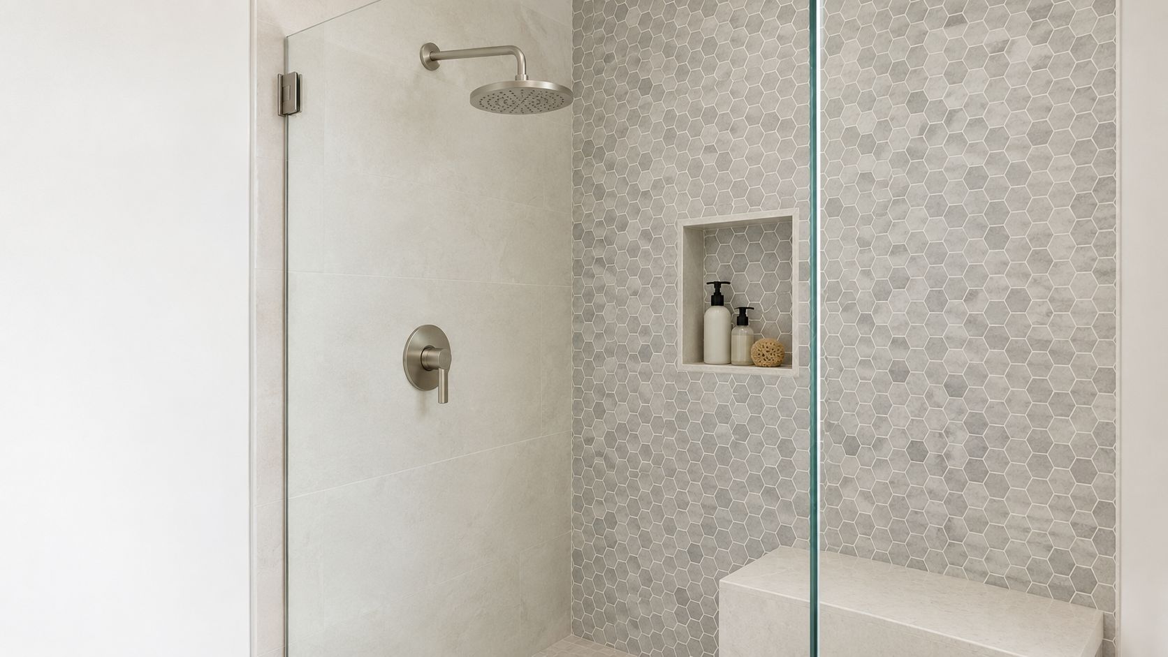 A modern shower featuring light beige large format wall tiles and a gray hexagonal mosaic tile accent wall.
